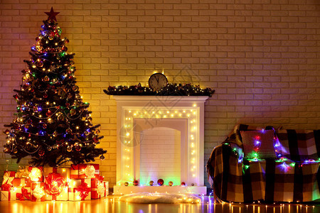 圣诞节树附近的白色壁炉和砖墙上的沙发图片