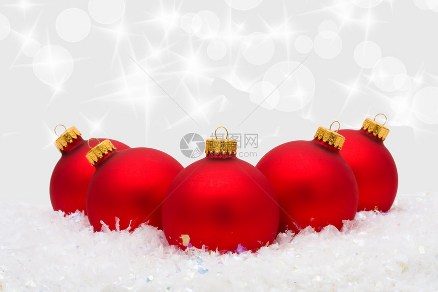 红圣诞装饰品在雪上有银本底的雪图片