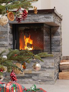 点燃的壁炉旁的圣诞树和圣诞礼物图片