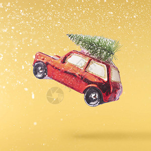 圣诞贺卡概念圣诞小汽车装饰在黄色背景的空气中坠落图片