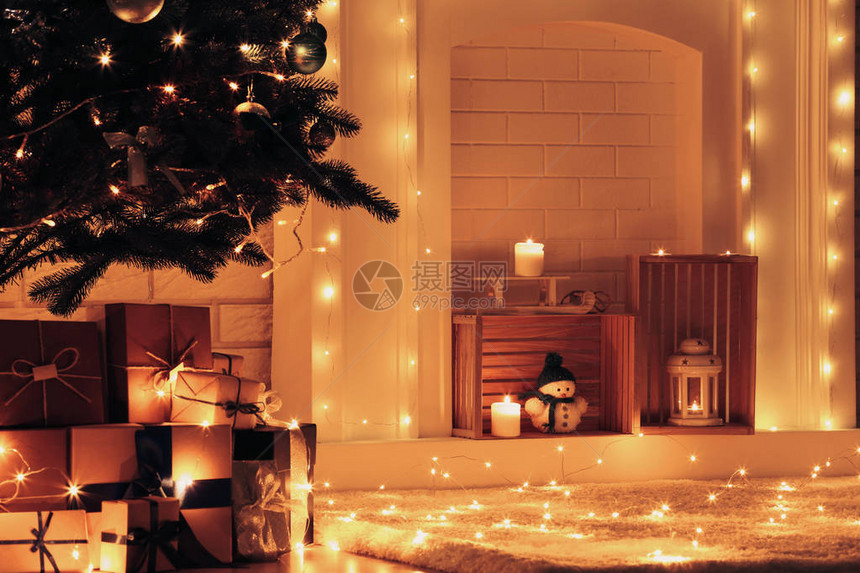 圣诞节树附近的白色壁炉在砖墙图片