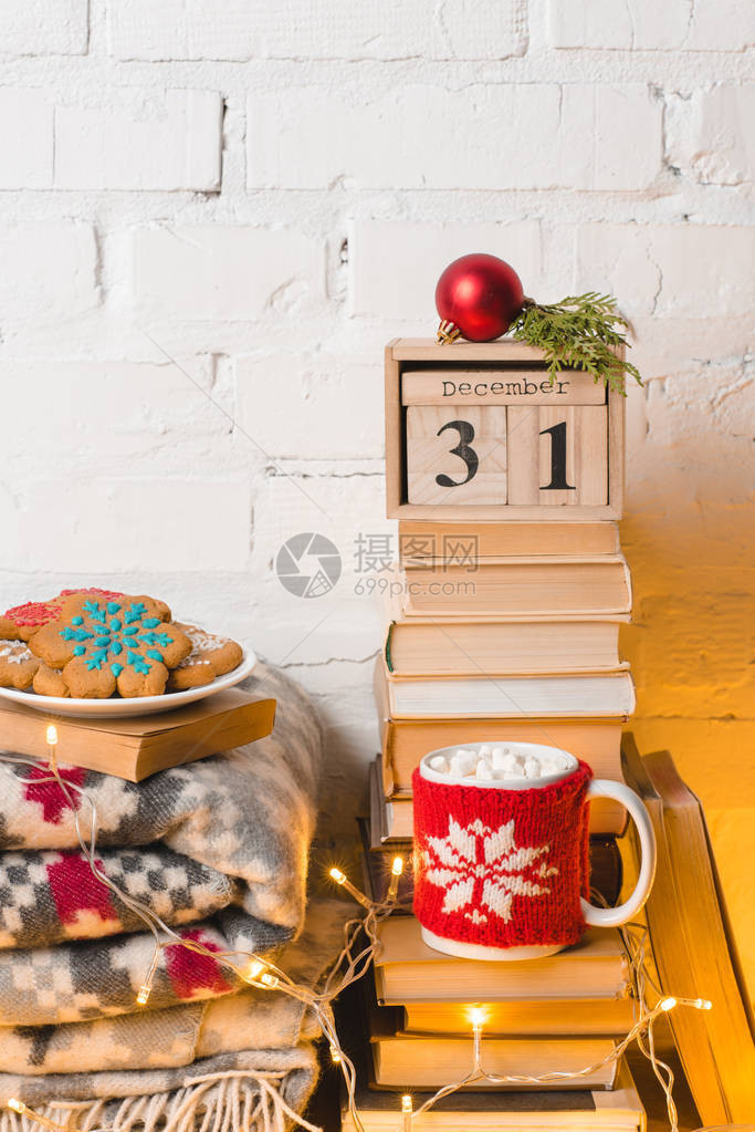 一堆书毯子姜饼干加棉花糖的热巧克力杯12月31日历图片