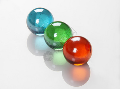 RGB颜色球白色反射背景上的Marbles图片