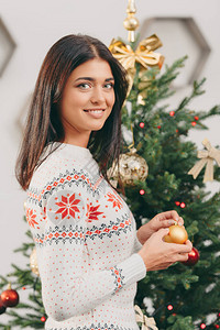 美丽的年轻女士装饰着圣诞树图片