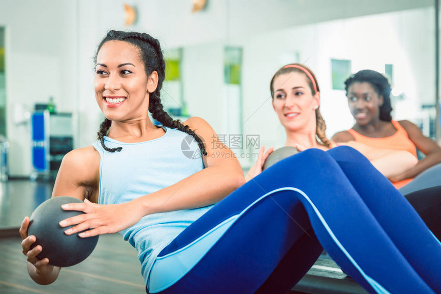 美丽的年轻女子在健身房妇女集体锻炼课期间图片