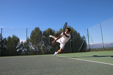 网球运动员在网球场上潜水接球图片