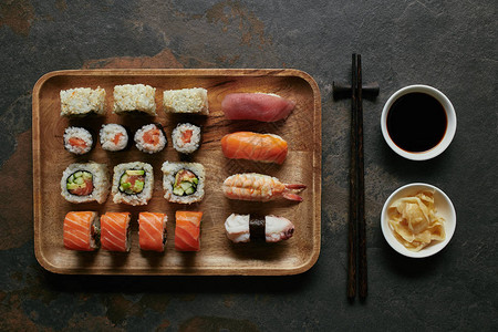 木板筷子姜汁和黄豆酱上的各类寿司在图片