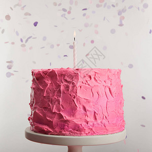 紧贴着美味的粉红生日蛋糕和蜡烛在灰色面纸条附近图片