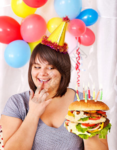 超重的女人在生日时吃汉堡包图片