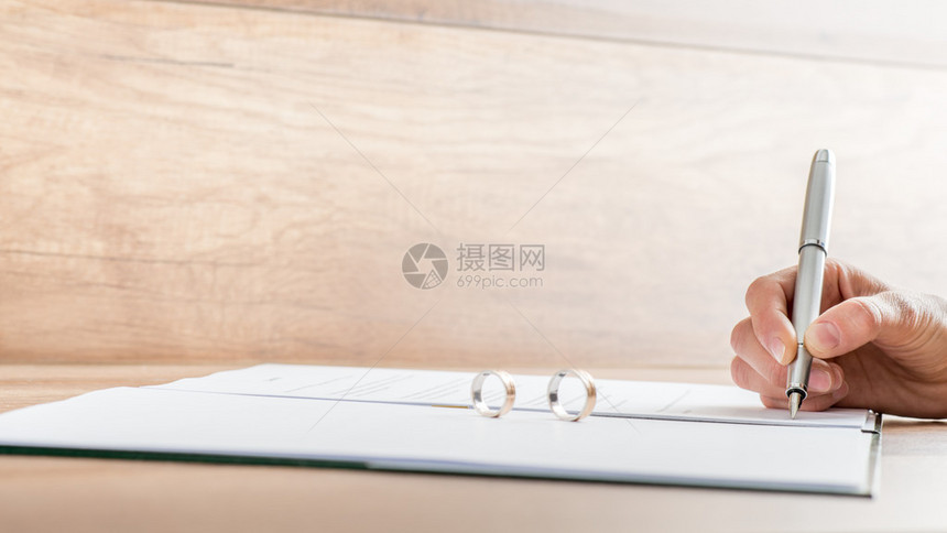 女手签署离婚文件的特写镜头与站立在文图片