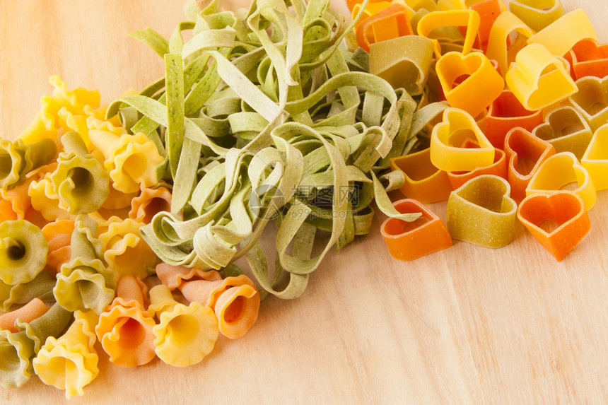 木制背景上的各种意大利面食Gigli意大利面菠菜意大利宽面条和图片