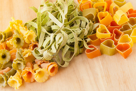 木制背景上的各种意大利面食Gigli意大利面菠菜意大利宽面条和图片