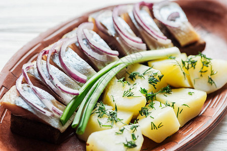 与土豆和洋葱相近的美味炒熟鱼在土瓷板上加图片