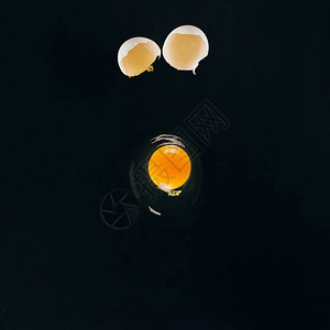 近距离观看生蛋黄落在黑色图片
