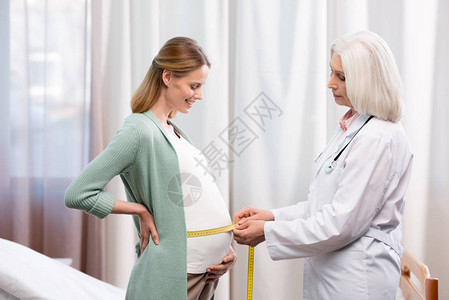医生在医院测量孕妇的腹部图片