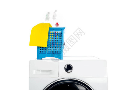 白色隔离洗衣机上带清洁用品的塑料篮图片