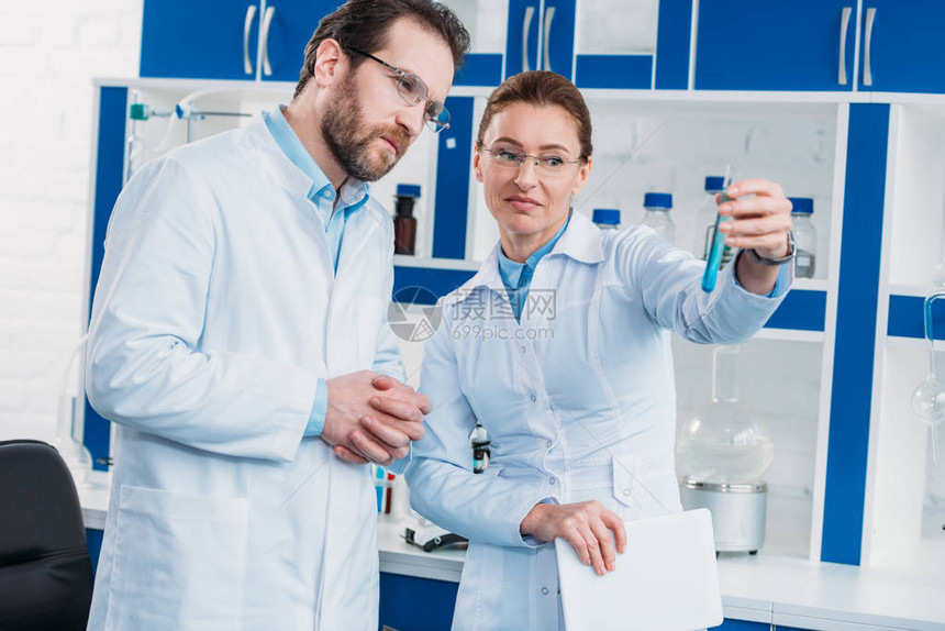 在实验室用试剂检查管子的眼镜中的科图片