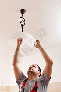 电机男把新的灯泡弄上天花板图片