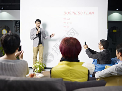 年轻的亚洲企业家介绍新项目的商业计划观图片