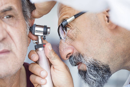 医生拿着耳镜检查老人的耳朵图片