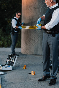 穿乳胶手套的中年男警官在犯罪现场设高清图片