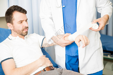 急诊室一名医生将男用伤员手腕图片