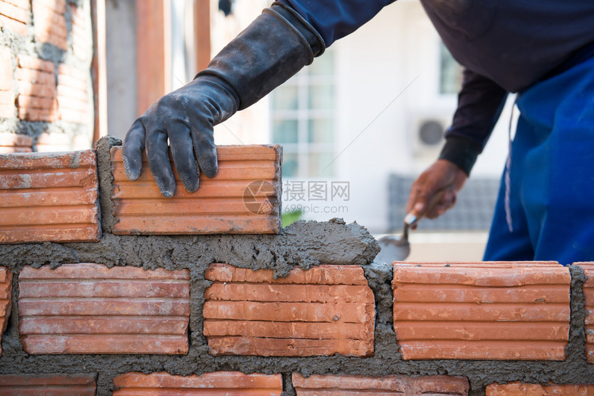 工人用砖头建砖瓦的图片