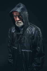 身穿黑色雨衣的高级大胡子男中半身背景图片