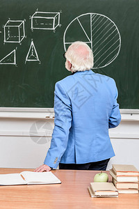 白发教授看黑板的后视图背景图片