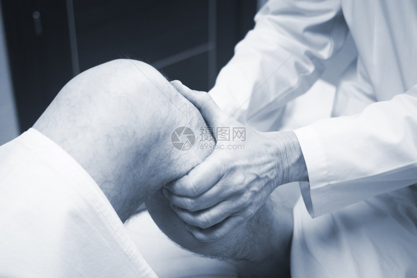 外科医生骨科医生检查中年男患者以确定受伤疼痛活动能力并诊断腿部膝关节半月板软骨脚踝和足图片