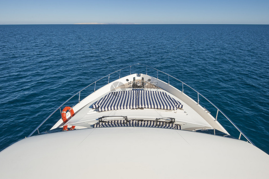 从豪华的大型私人具有地平线的机动游艇船首对热带图片
