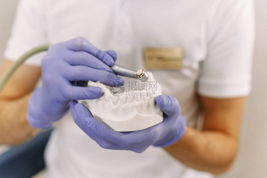 牙医拿着带有植入物的钻头在牙科治疗过程中牙科诊所患者牙齿使用的牙科钻图片