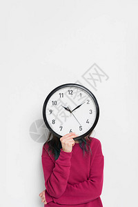 女人用时钟遮着脸背景图片