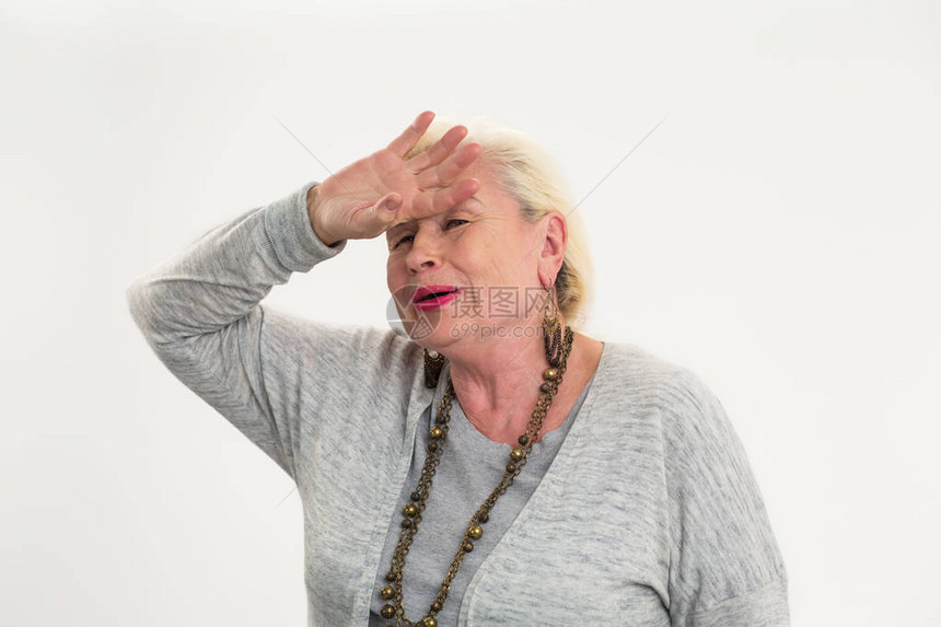 年纪大的女人触摸她的额头身陷白种背景的疲劳女人剧烈图片