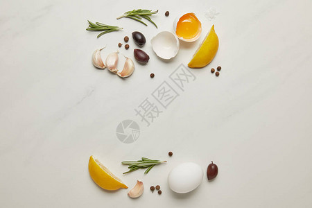 用生鸡蛋迷迭香大蒜和黑胡椒成分铺在白大理石表面图片