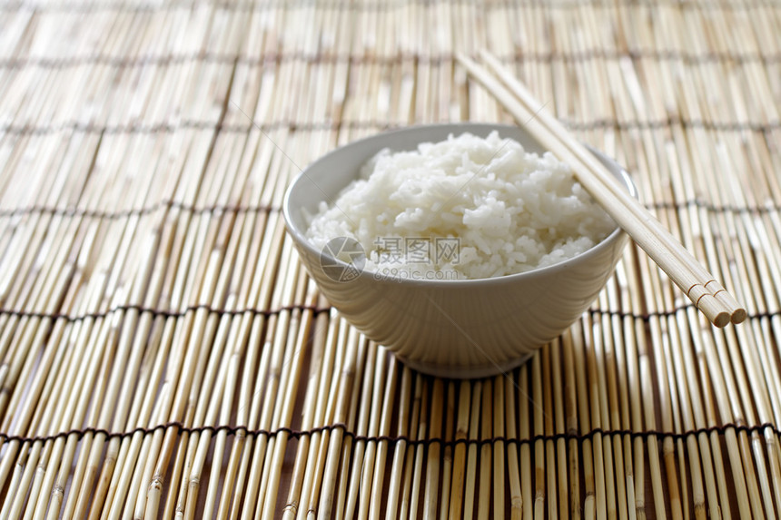 一碗米饭和竹子上的筷子图片