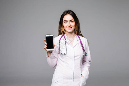 年轻女医生在灰色背景下看手机高清图片