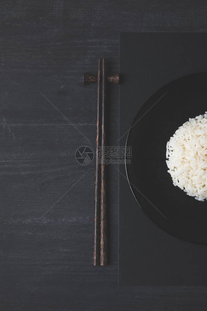 黑桌上米饭和筷子的俯视图图片
