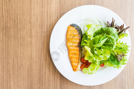 白盘中的鲑鱼和蔬菜沙拉图片
