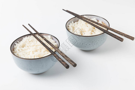 一碗美味的米饭白色的表面上有筷子图片