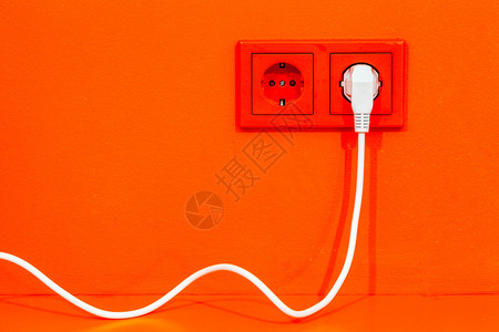 带欧洲电插座和白线的亮橙色墙壁图片