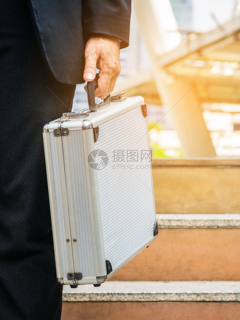 商人在城里拿着金银公文包图片