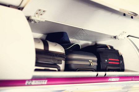 带手提箱的手提行李隔间在飞机上飞机顶架上的随身行李带有复制空背景图片