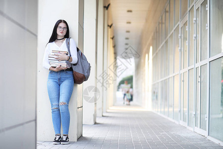 街上背着书包和书的年轻女学生图片