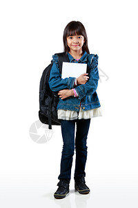 满身年幼的亚洲女孩站着拿书本被孤图片