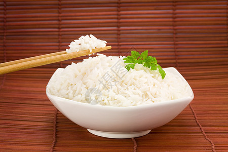 筷子上的米饭和垫子上的碗特写图片