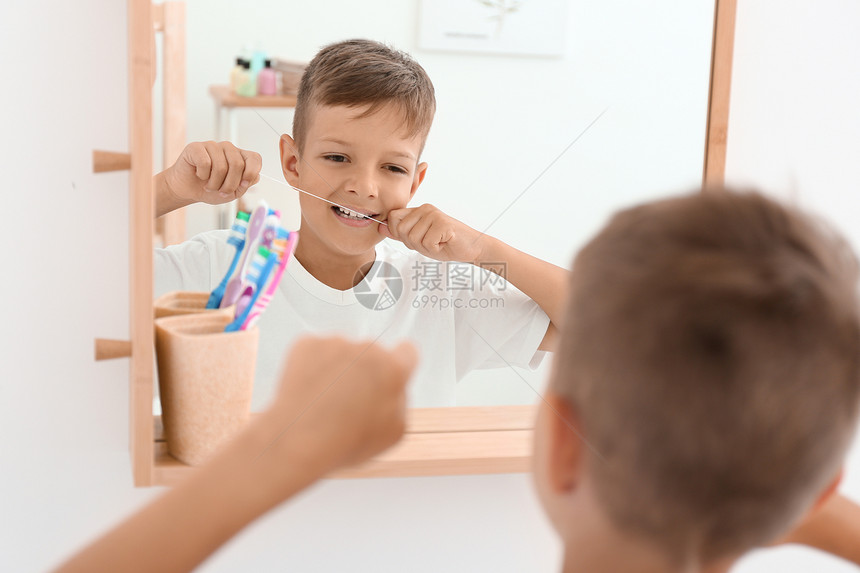 小男孩在浴室里用牙线刷牙图片