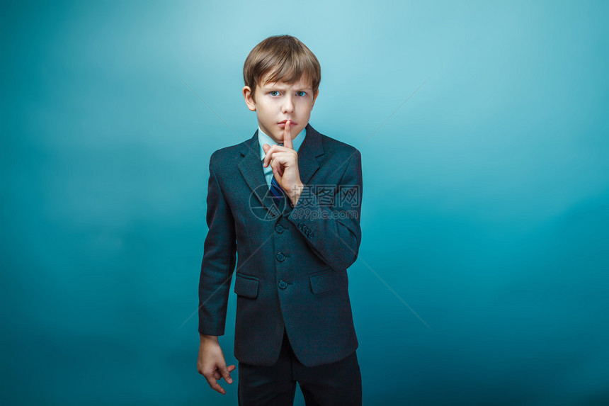 身着商业西装的欧洲少年男孩将他的手指伸到嘴里图片