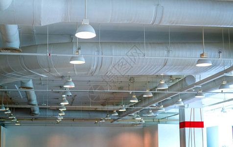 风管空调管接线管消防喷淋系统气流和通风系统建筑内部天花灯带开灯背景图片