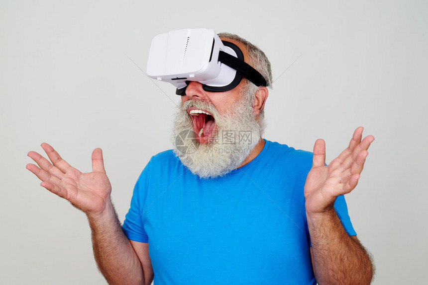 VRheadset的适龄男子惊讶于这个科技提供的白种背景与世隔绝的图片